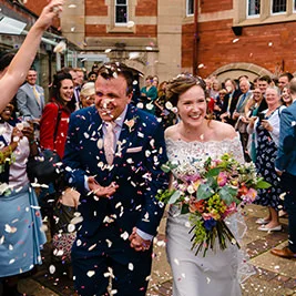 Confetti being thrown over a wedding couple